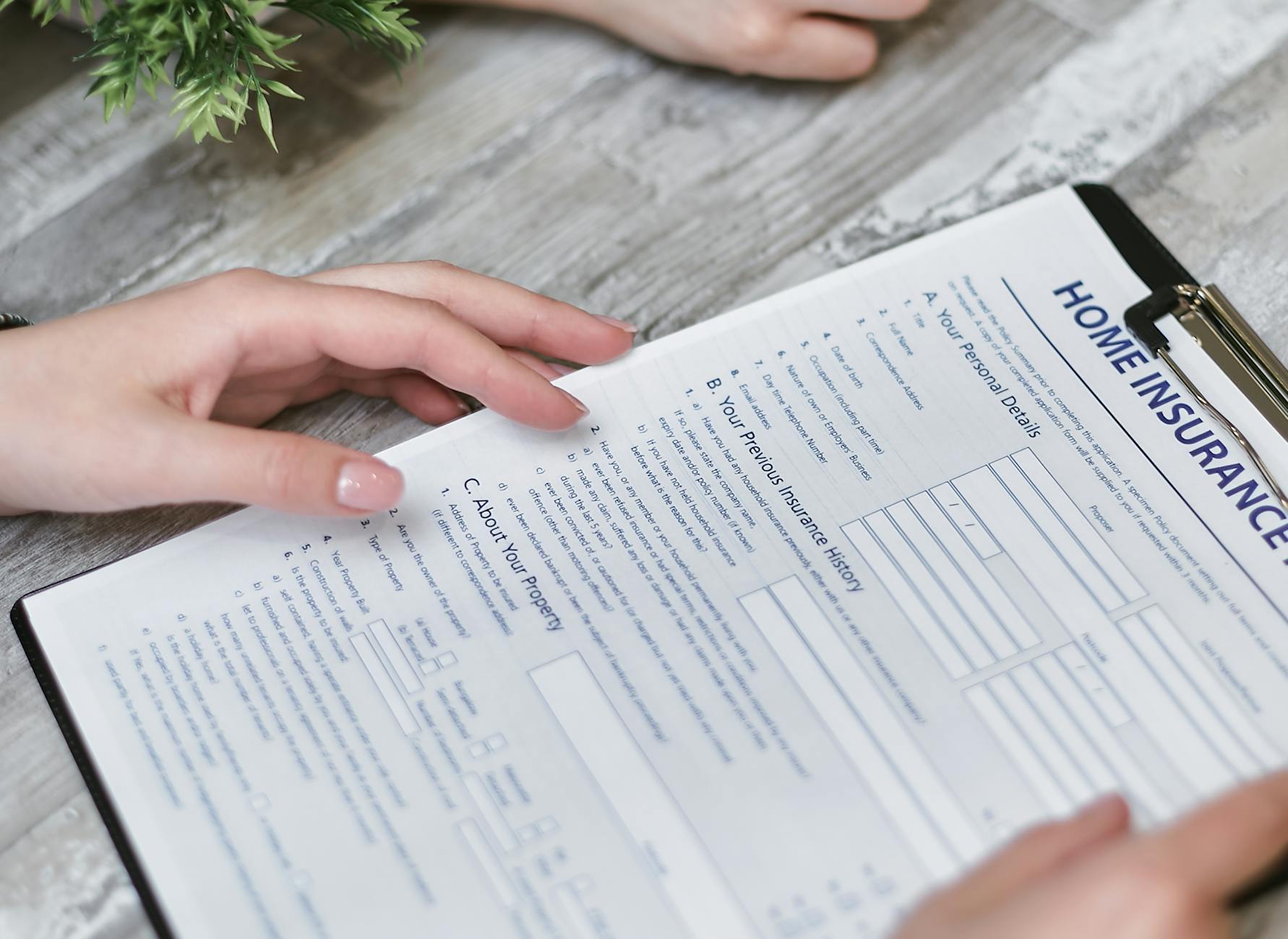 Oklahoma homeowner reviewing roof insurance claim paperwork at a kitchen table