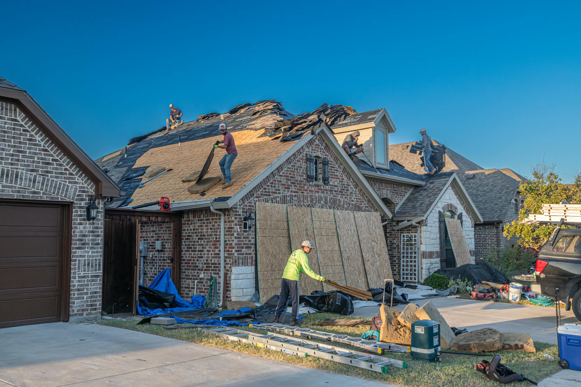Oklahoma City homeowner inspecting roof shingles with a roofing contractor
